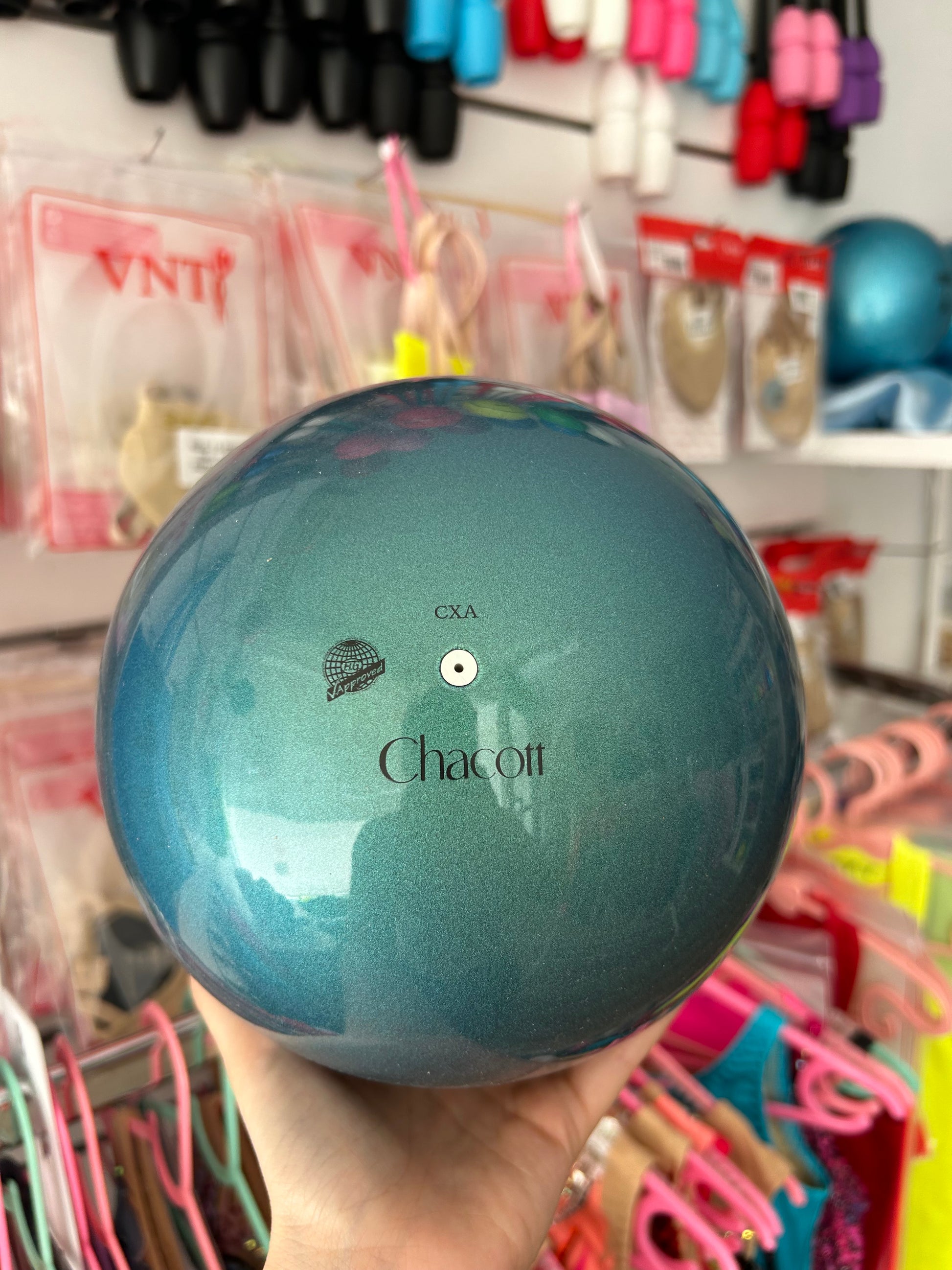 La pelota de competición Chacott para gimnasia rítmica está diseñada para ofrecer un rendimiento óptimo tanto en entrenamientos avanzados como en competiciones oficiales. Fabricada con materiales resistentes y un acabado de gran calidad, proporciona un tacto agradable, un agarre seguro y una trayectoria estable durante lanzamientos, rodamientos y elementos técnicos.

Su superficie uniforme favorece un control preciso del aparato, permitiendo a las gimnastas ejecutar movimientos con mayor seguridad